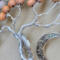 details of twisted aluminum branches rising from a twin tree trunk